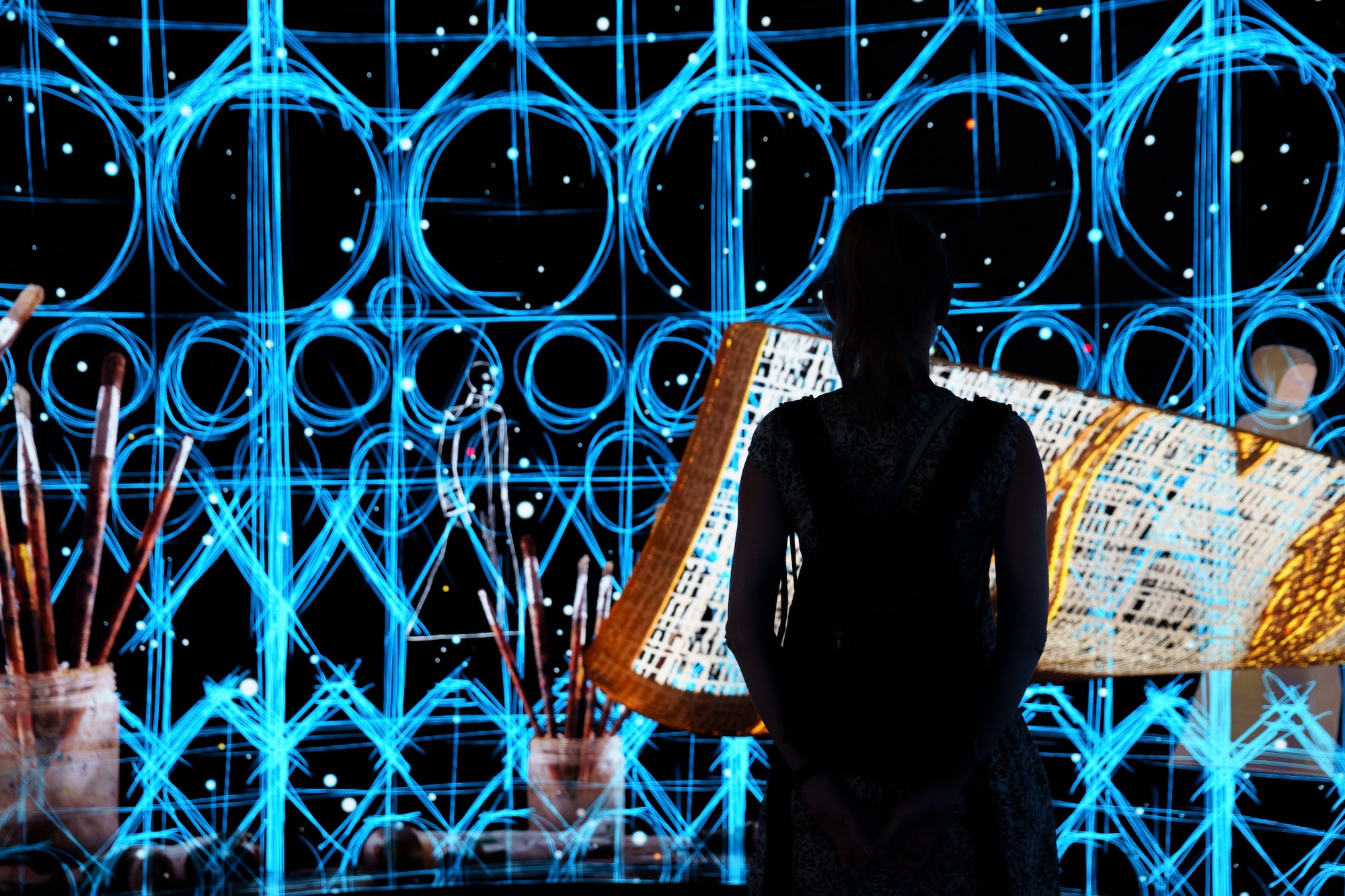 Woman silhouette in front of Digital art panel in one of the Expo in Dubai